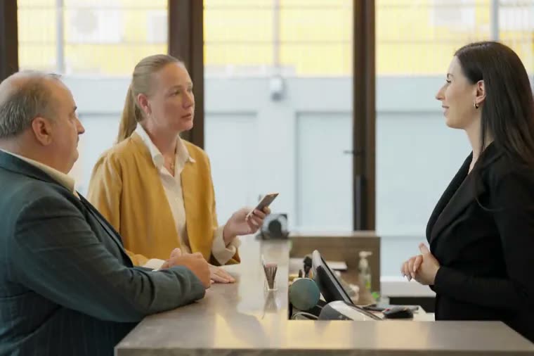 Hotel guests speaking with a staff member at a reception desk
